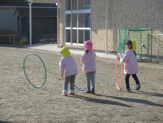 写真：フラフープを転がして楽しむ女の子達