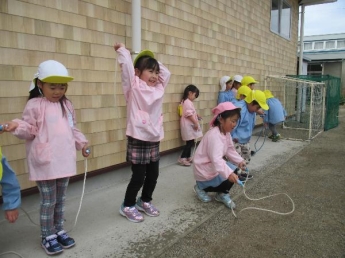 写真：雨宿りしながらもなわとびを跳びたい園児たち