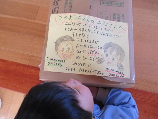 写真：干しいもと一緒に届いたお手紙を読もうとしている男児