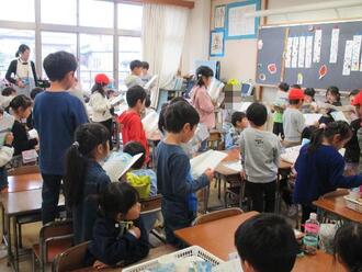 写真：小学生が音読をするのを聞く園児達