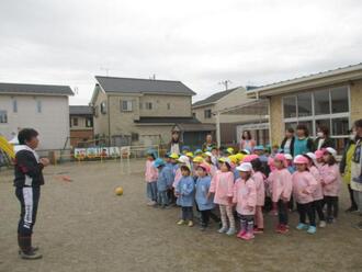 写真：避難訓練後に園長先生の話を聞いている様子