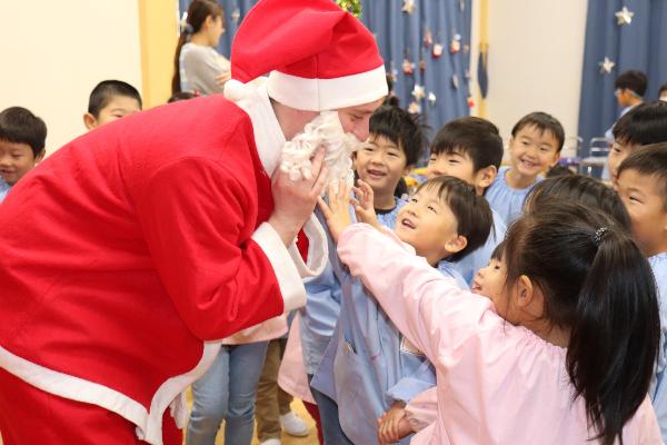 写真：サンタさんと握手を交している園児達