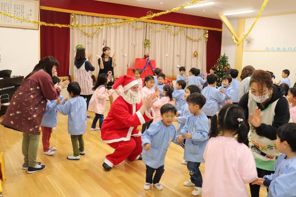 写真：サンタさんと園児達がダンスを踊っているところ