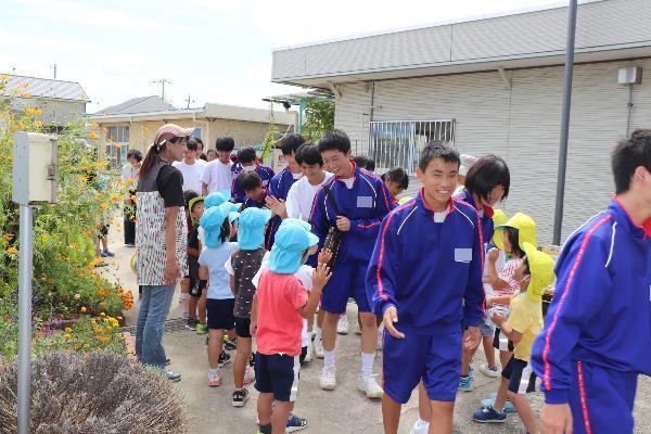 写真：中学生が帰る際に花道を作る園児達