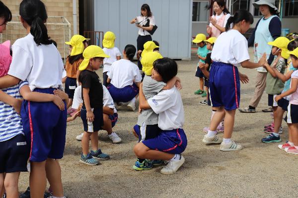 写真：お別れを惜しんでハグしている園児と中学生