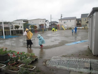 写真：大雨の中降園する親子