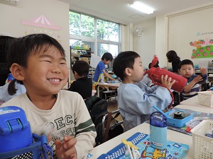 写真：年少さんの初めてのお弁当、お友達と一緒を喜んでいる男児