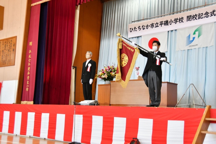 写真：平磯小学校長から学校旗を受け取る大谷市長