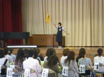 交通安全教育指導員が小学生の保護者へ立哨指導のやり方を説明している写真