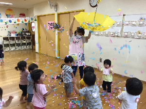 写真：傘から降る色とりどりの紙吹雪に歓声を上げる子どもたち