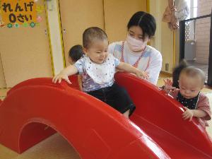 写真：すべり台で遊ぶ0歳児の子ども