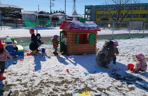 雪が積もった園庭で走り回ったり雪遊びをしている写真