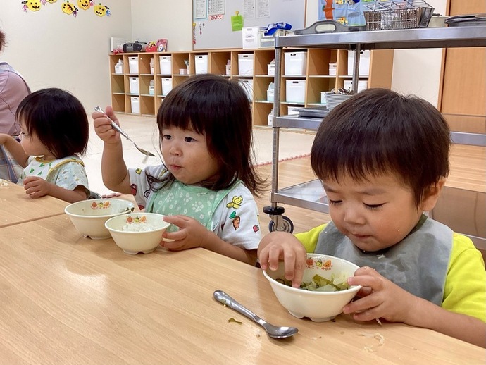 給食をおいしそうに食べる1歳児の写真