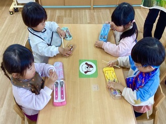 給食の時間、自分でお箸の準備をする2歳児クラスの子どもの写真。