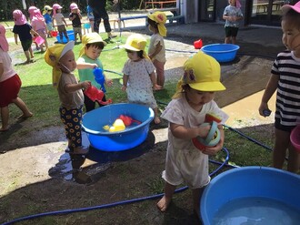 水遊びを楽しむ1歳児の写真