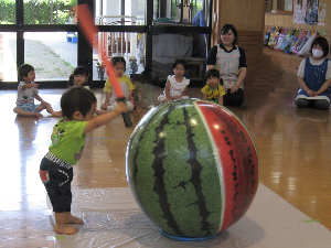 写真：大きなすいかのビーチボールですいか割りをする子ども