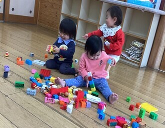 ブロックで楽しく遊ぶ0歳児の写真