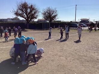 園庭で鬼ごっこをしようと、鬼決めをしている3歳児の画像