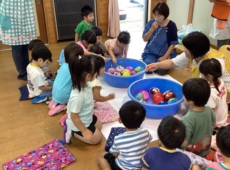 ヨーヨー釣りを楽しむ3歳児の写真