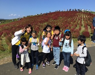 コキアの前で写真を撮る子ども達