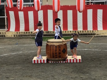 写真：夏祭りで太鼓の最後のポーズを決める子どもたち