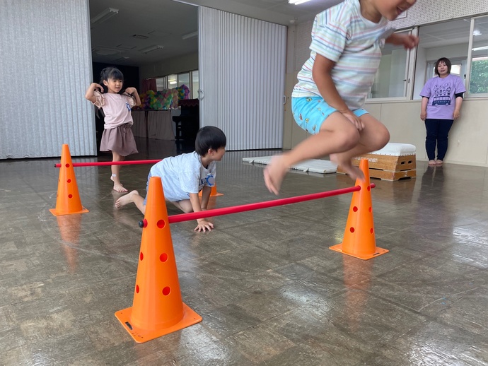 バーをジャンプする子ども