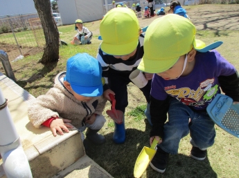 写真：ダンゴムシを見つけて喜ぶ子ども達