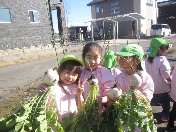 写真：収穫した大根を嬉しそうに見せる子どもたち