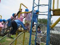 写真：小学校の固定遊具で遊ぶ園児