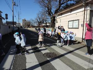 写真：手を挙げて横断歩道を渡っている様子