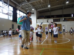 写真：逃げるお父さんのかごを追いかけて玉を入れる年長さん