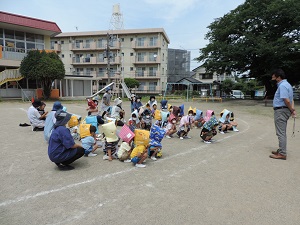 写真：園長先生が避難訓練で全員無事に避難できたことを園児に伝えている様子