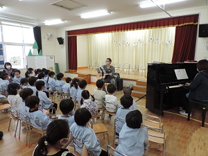 写真：誕生者のお父さんがギターの演奏を子ども達にしてくれているところ