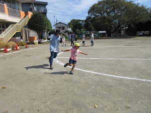 写真：先生と競走をする年長男児