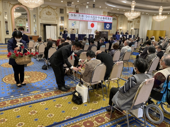 写真：参加者にお祝いの花を手渡す大谷市長