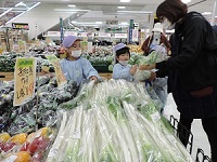 たくさんのねぎの山からいも汁に入れるねぎを先生と一緒に選んでいる年長児