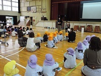 写真:学校の体育館に集まり交流会が始まる様子