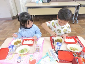 写真：おいしく給食を食べている年長児の様子