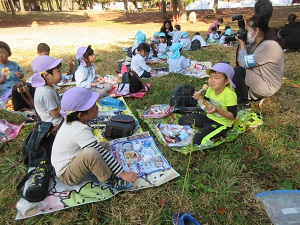 写真：海浜公園でみんなで楽しくお弁当を食べている様子