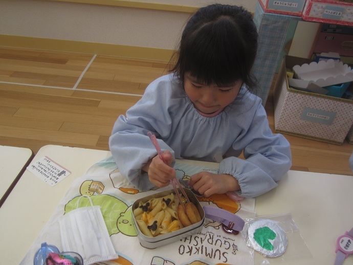 写真 最後のお弁当を食べる女児