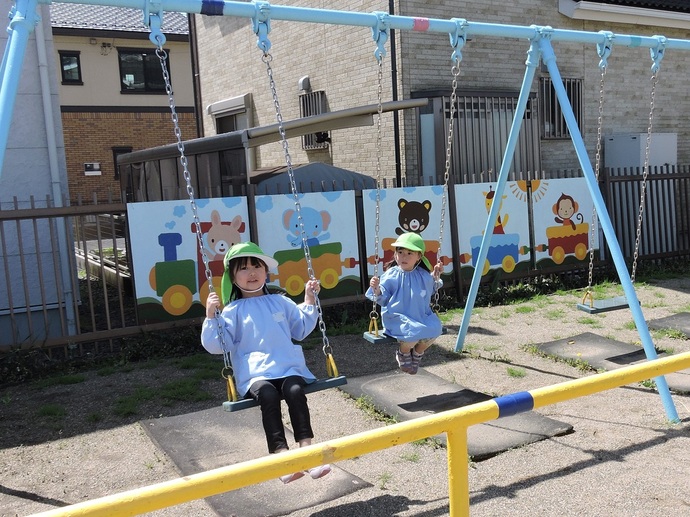 写真 ブランコで遊ぶ女児