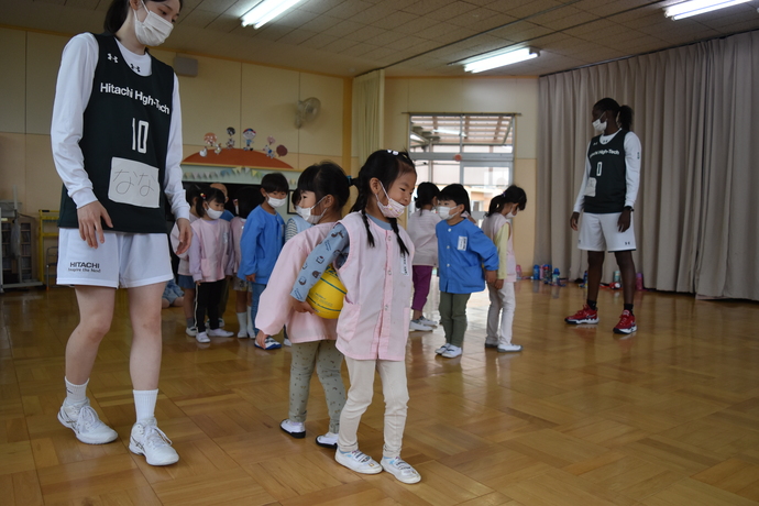 二人で背中でボールを挟んでいる幼児