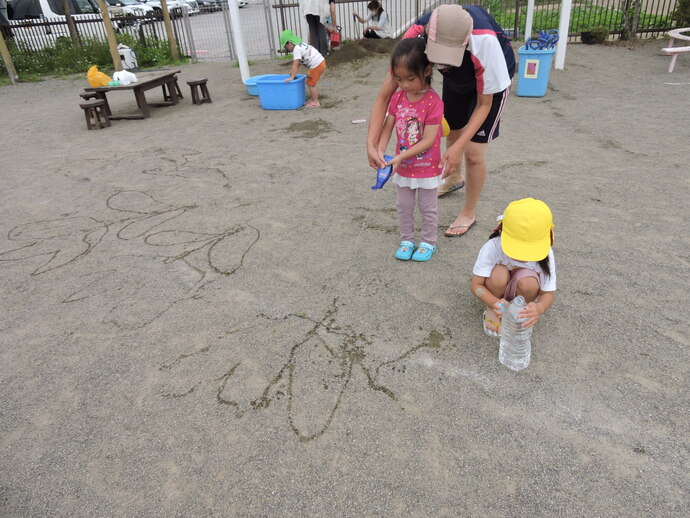 写真 水で絵描く幼児