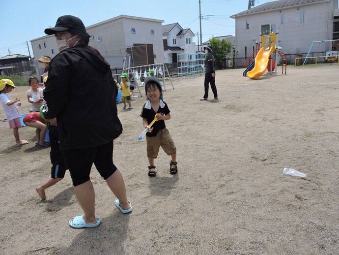 写真 水鉄砲で遊ぶ幼児