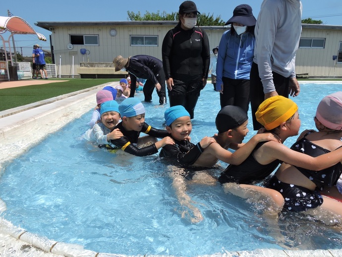 写真 水の中で電車ごっこをする幼児