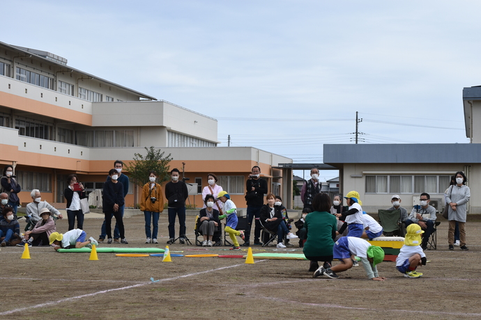 マットを這ったり、フープを跳んだりしている園児。