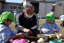 写真 砂のままごとをする幼児