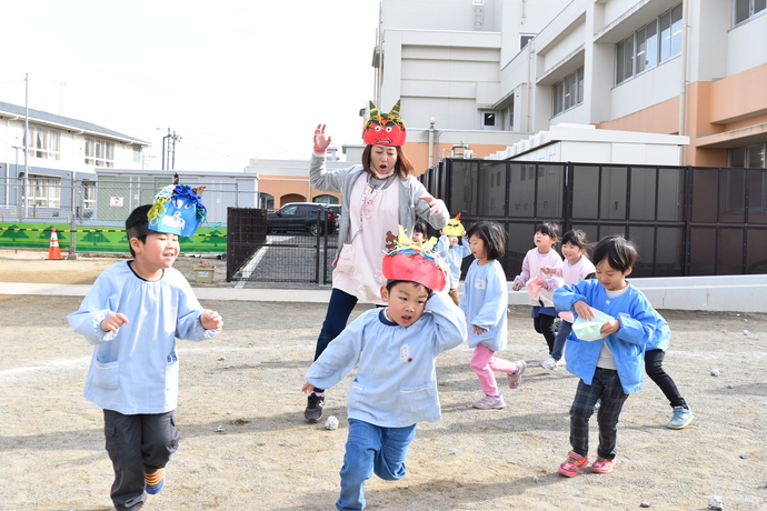 鬼のお面をかぶって園児を追いかける教師と園児