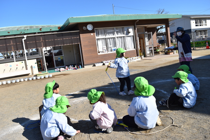 縄跳びをする園児を囲んで見る園児