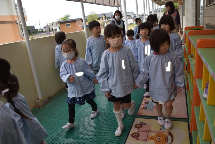 テラスで手をつないで歩く園児達